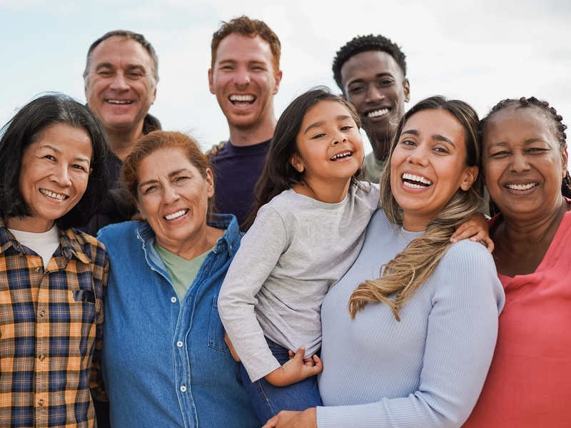 A diverse group of people smiling together for a group photo