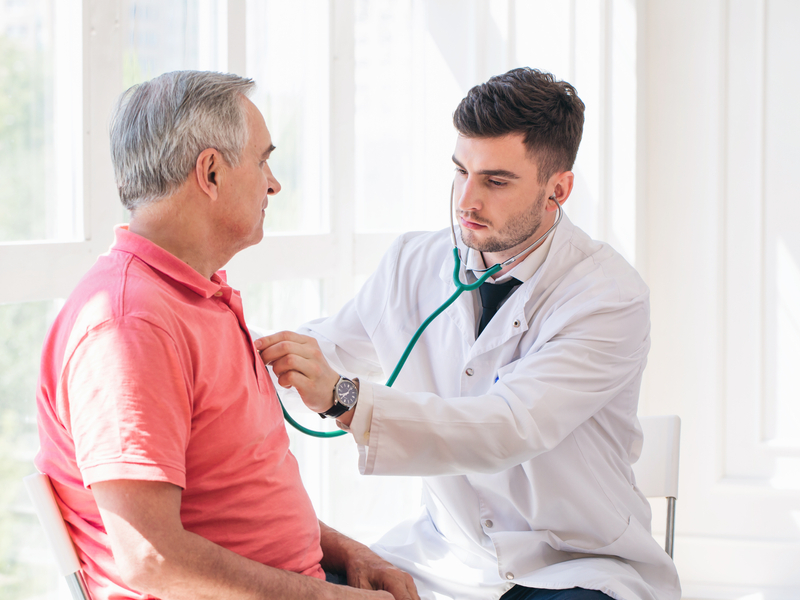 doctor listening to a older male patient's heart rhythm 