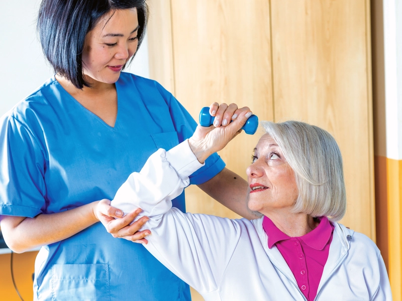 Physical Therapist helping a patient with exercises tailored to treat essential tremors