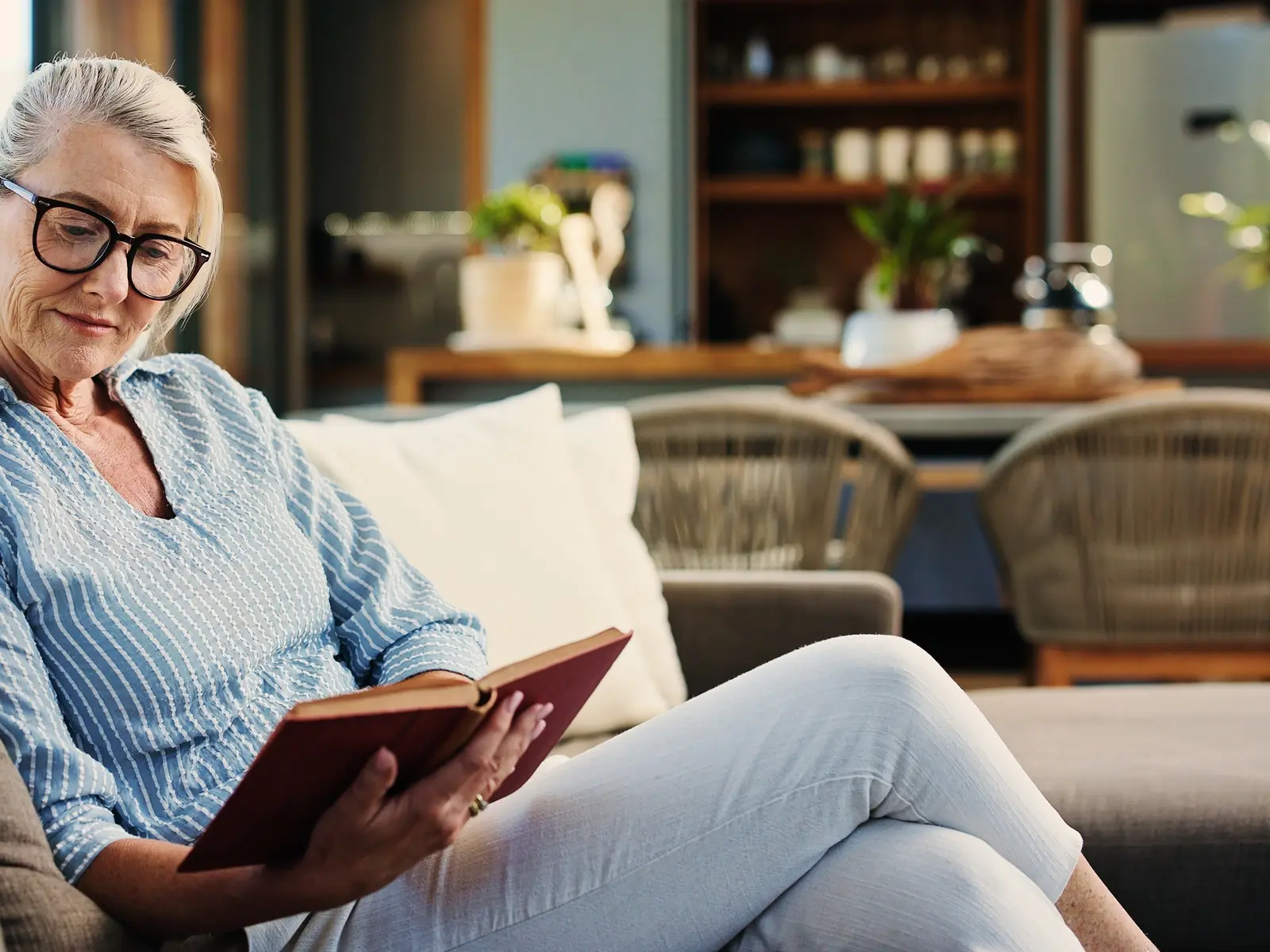 A woman relaxes on her couch after learning about the link between stress and high blood pressure.