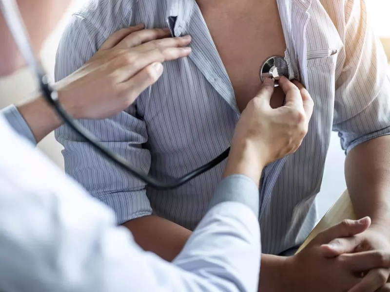 medical provider using stethoscope to listen to patient's arrhythmia