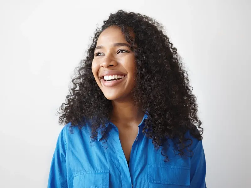 A woman smiles while looking in the distance