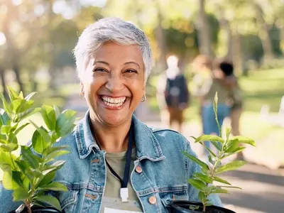 A woman outside holding a plant, looking at how to boost energy