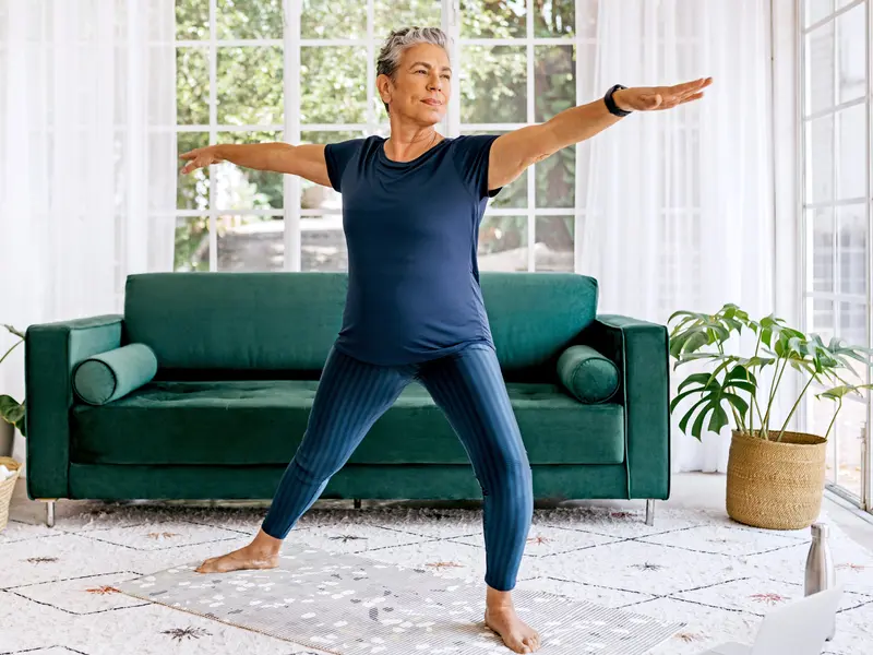 woman stretching to relieve ankle pain in living room