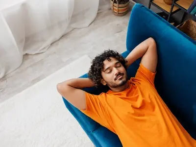A man resting on a sofa after learning how to sleep with GERD