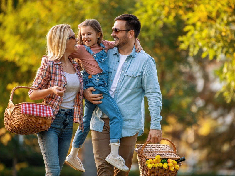 Family with a young daughter enjoying a picnic outside
