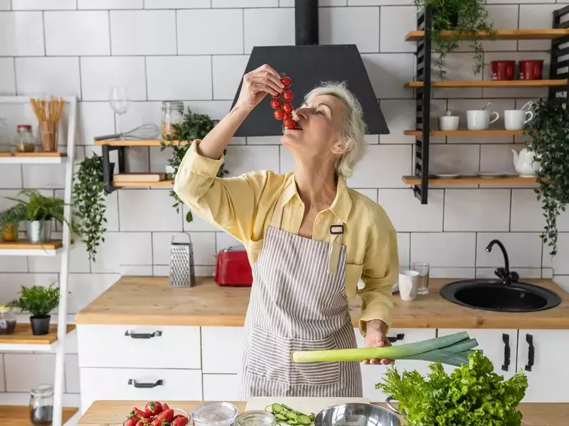 Elderly woman in the kitchen surrounded by heart healthy foods