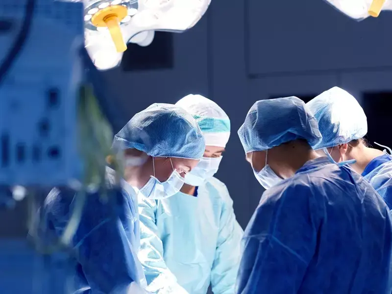 Vascular surgeons and medical staff performing Endovascular Aneurysm Repair (EVAR) in an operating room