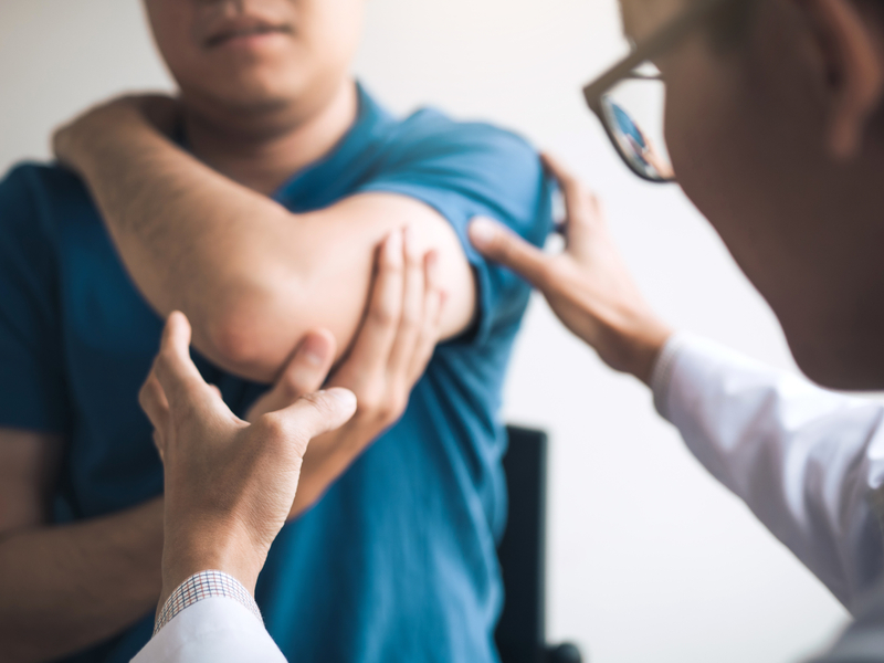 orthopedic doctor examining a patients shoulder