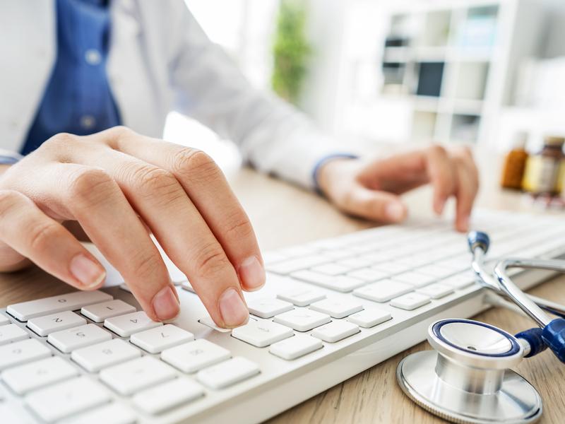 Medical provider typing on keyboard to respond to a patient's private message about a health concern