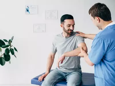 A man receiving physical therapy from a doctor for a frozen shoulder