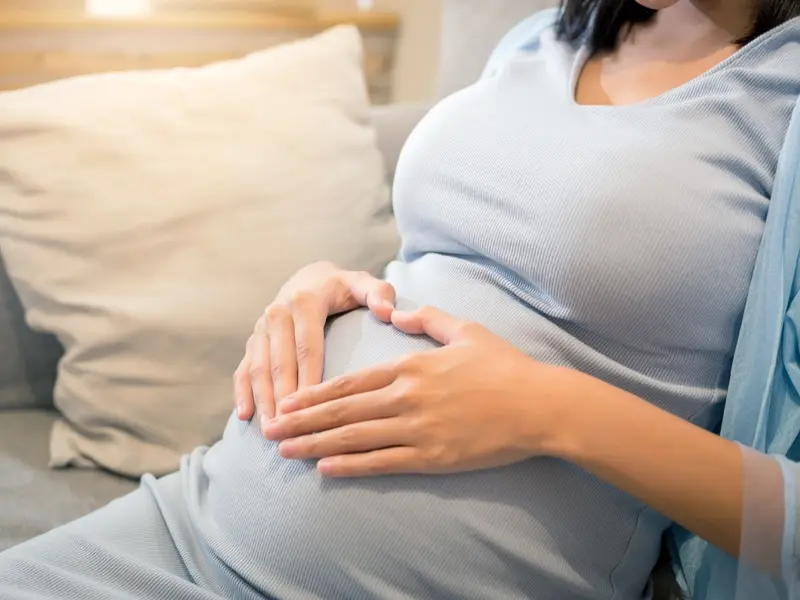 Women touching pregnant belly