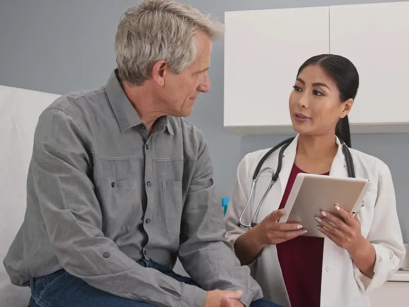 Vascular surgeon discussing candidacy for endovascular aneurysm repair (EVAR) surgery with male patient
