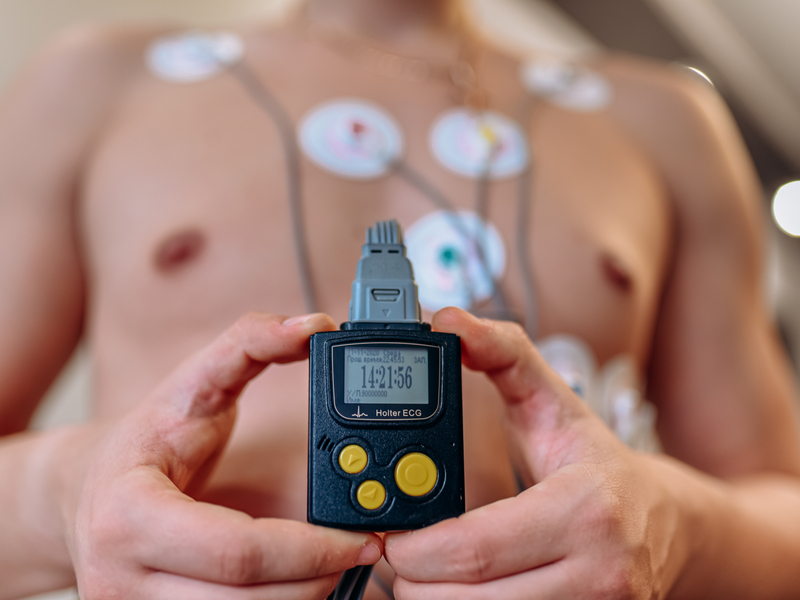 Patient connected to and holding an ECG monitor