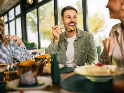 A group of friends having lunch, asking, “Can you have acid reflux and not know it?