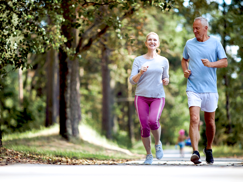 older couple taking care of their joint health by jogging in nature