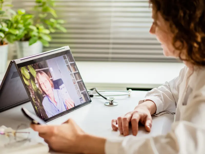 Older woman speaking with a medical professional via tablet for virtual back and neck care from Baylor Scott & White