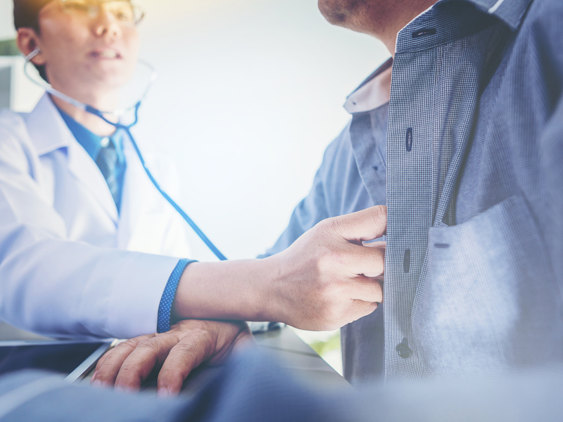 médico hablando de las complicaciones de la artritis psoriásica con un paciente