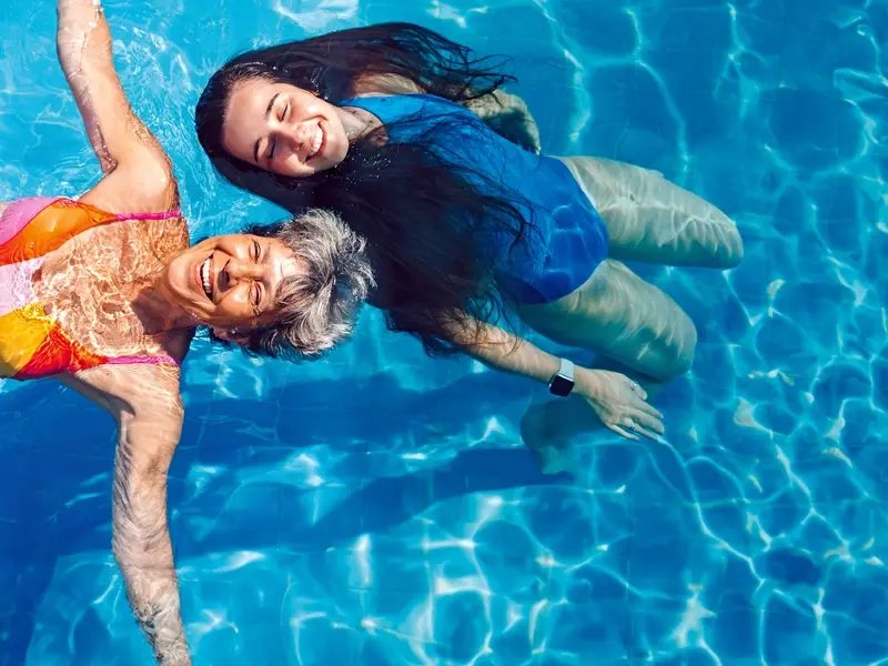 two women having fun in the pool