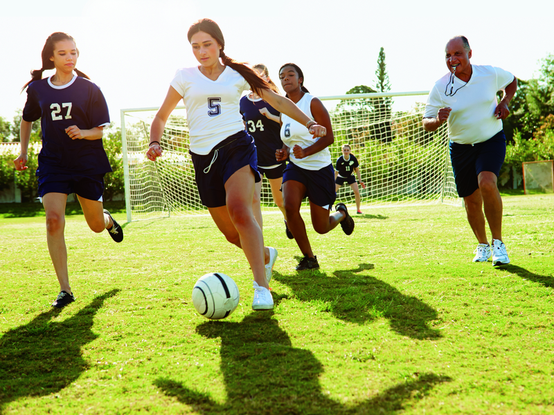 athletes playing soccer outside