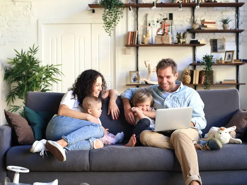 family enjoying being together on the couch while the father researches cystoplasty on a laptop