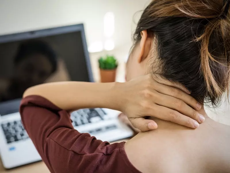women dealing with thoracic outlet syndrome sitting at her desk 