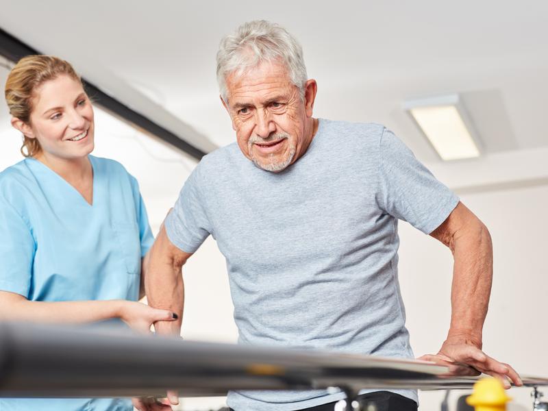 Physical therapist supervising an older man during exercise therapy as part of a cardiac rehabilitation program