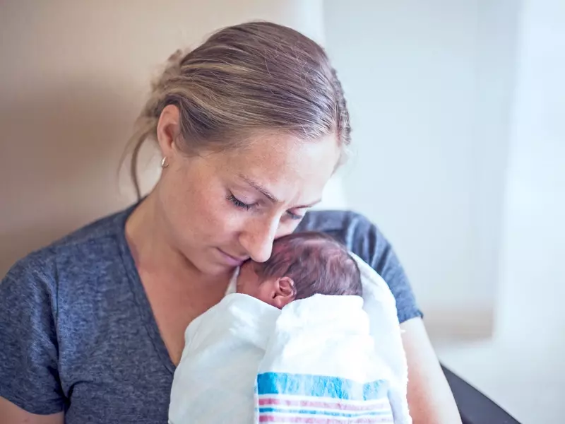 mother cuddling her premature newborn