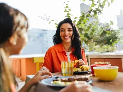 A woman living with food noise, sitting down to eat a meal 