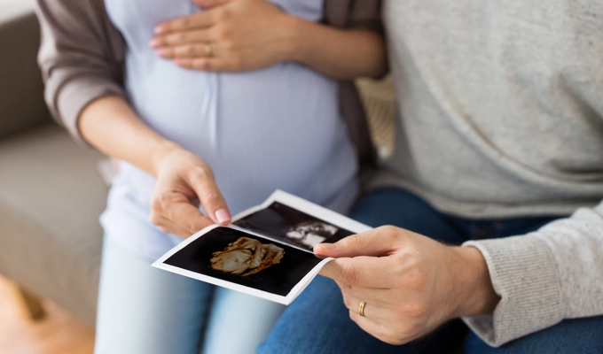 expectant parents looking at sonogram of their baby