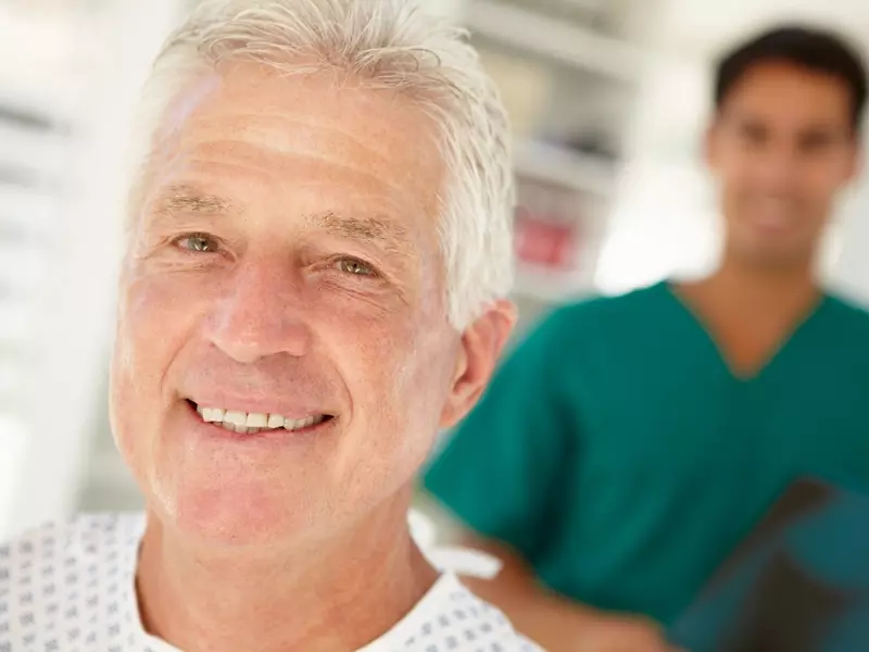 senior male patient with provider in background