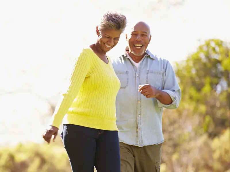 man with hip pain and woman smiling outside on a sunny day