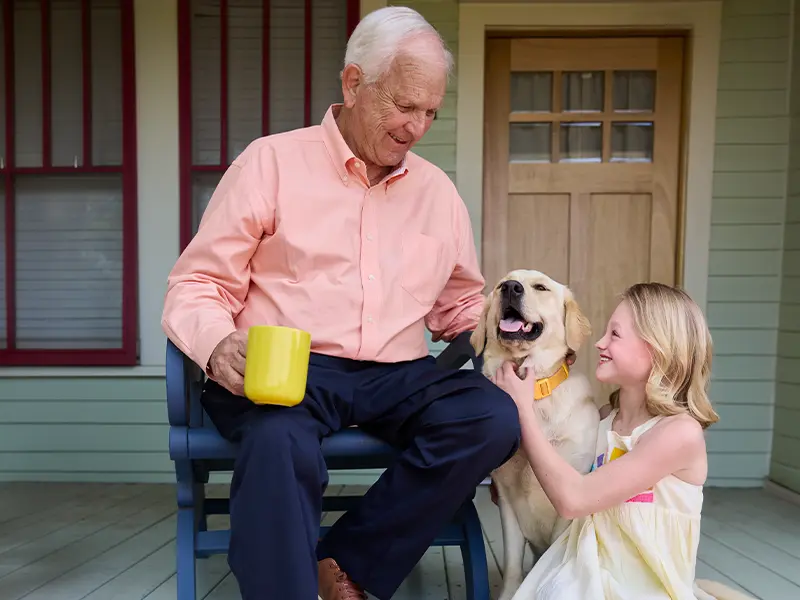 Grandfather with granddaughter on porch