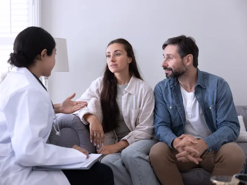 a doctor discussing infertility risk factors with a couple
