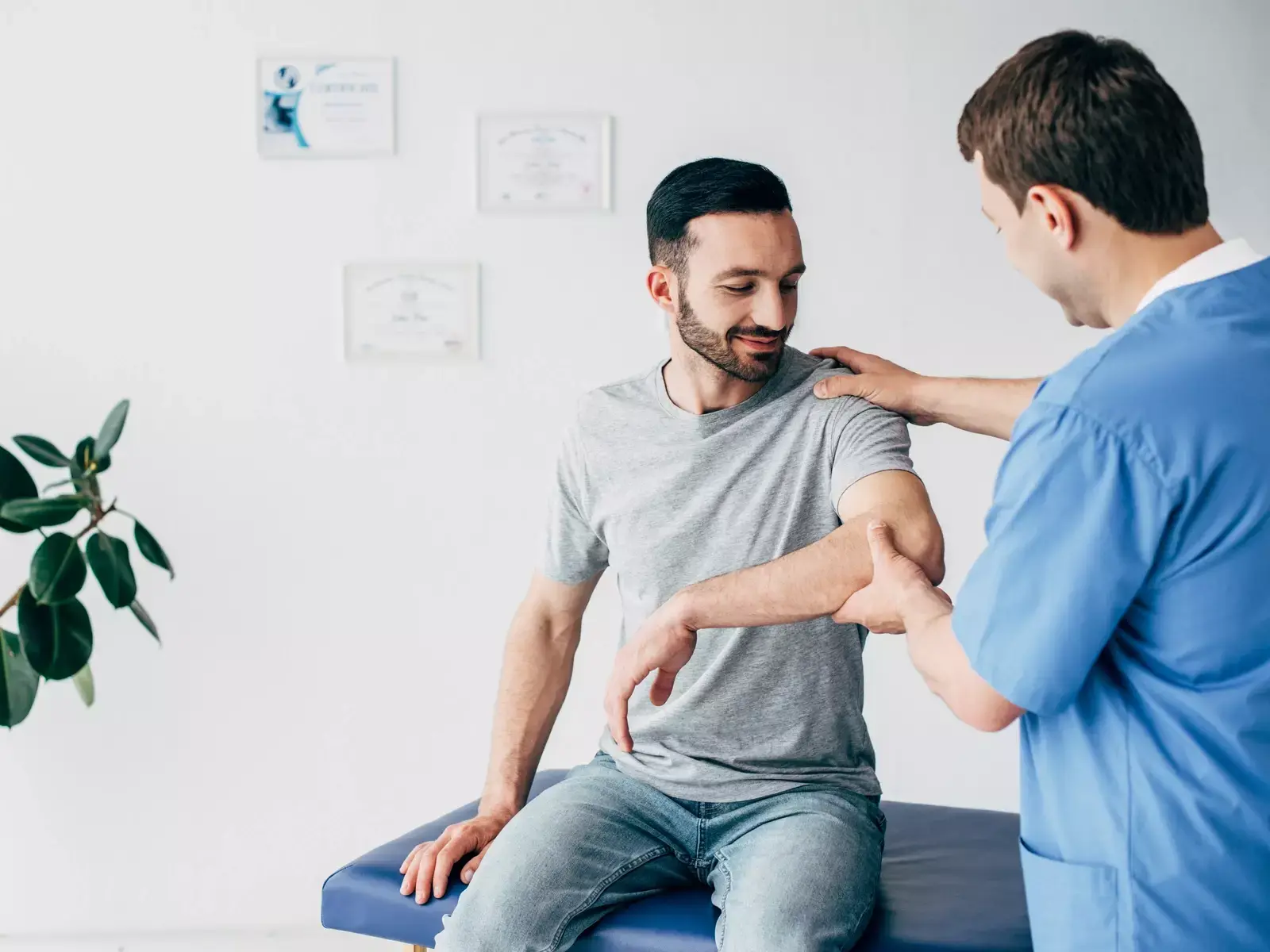 A man receiving physical therapy from a doctor for a frozen shoulder