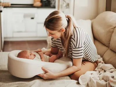 A woman with her newborn baby on her postpartum recovery journey